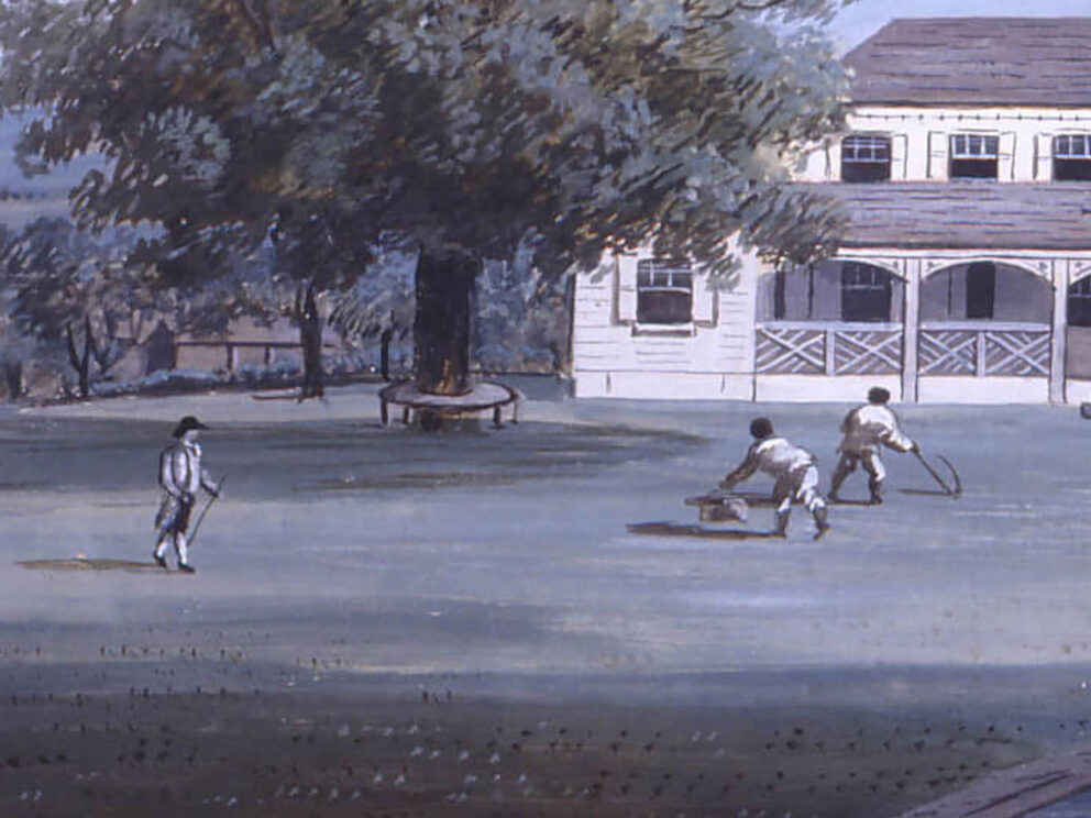 An 18th century watercolour painting shows a gentleman dressed in black breeches with a black hat and cane walking beneath the spreading branches of a mature tree toward a group of enslaved people dressed in white shirts and breeches engaged in gardening work. To the rear right of the painting is the plantation house, two stories with a verandah.