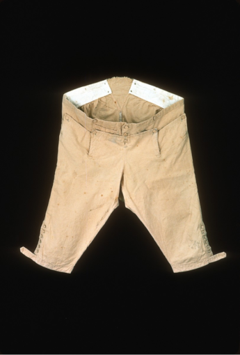 A pair of buttoned knee length breeches in a yellowish heavy weight cotton. These are nankeen breeches favoured by 18th century gentlemen now in the collection of Colonial Williamsburg