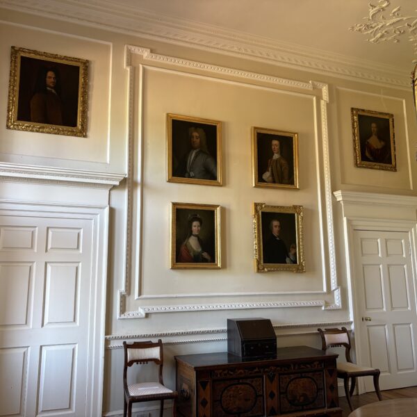 Entrance Hall showing some family portraits, a small writing bureau, 2 chairs and a travelling chest.