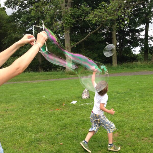Children playing with giant bubbles